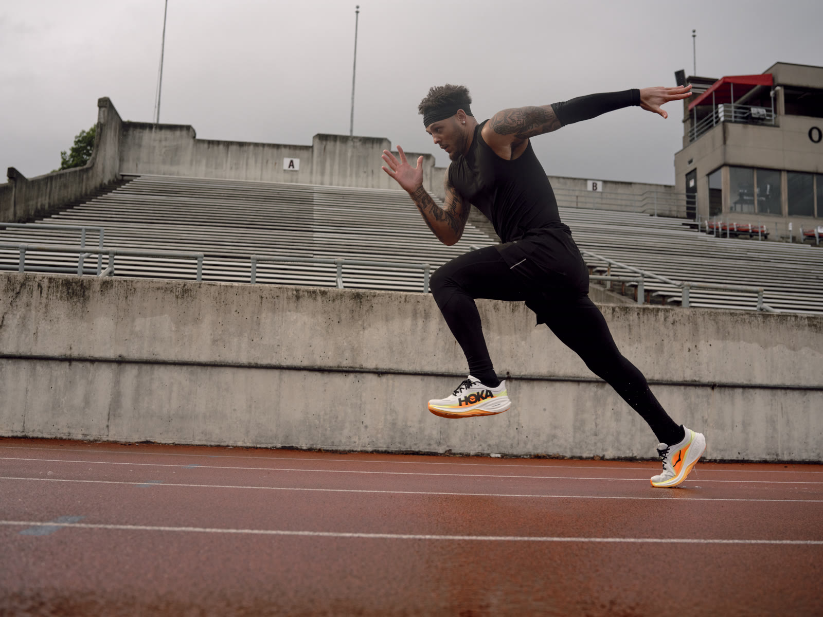 Brandon Inniss sprints on the track in front of the bleachers at Selby Stadium.