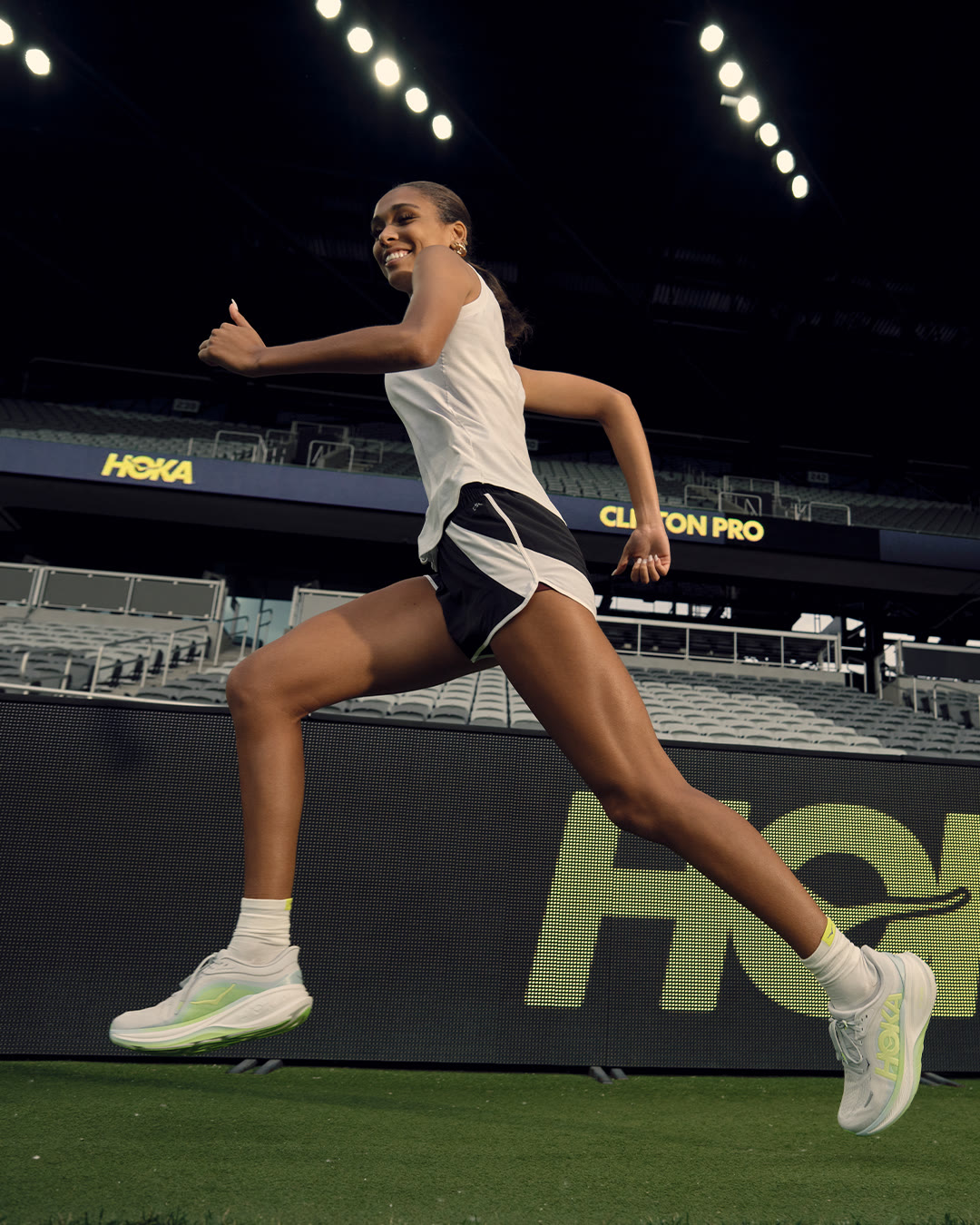 Anaiyah Robinson gives a thumbs up while running through the Columbus Crew's stadium at dusk.